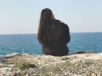 Rear view of woman looking at sea against sky