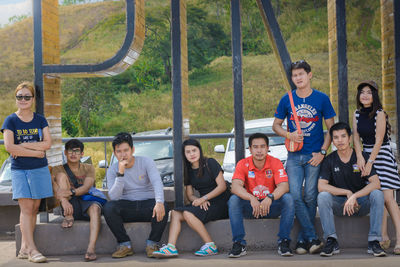 Full length portrait of friends sitting in park