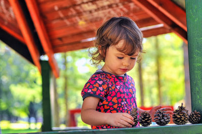 Young girl with pine cones