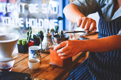 Midsection of woman preparing coffee on table