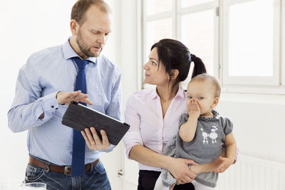 Couple with baby girl using digital tablet