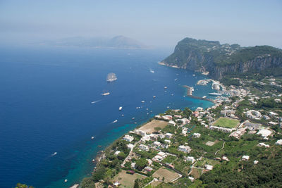 High angle view of town by sea against sky