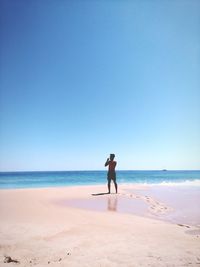 Full length of man on beach against clear sky