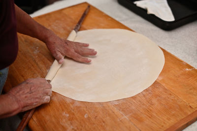 High angle view of person hand on table preparing pastry