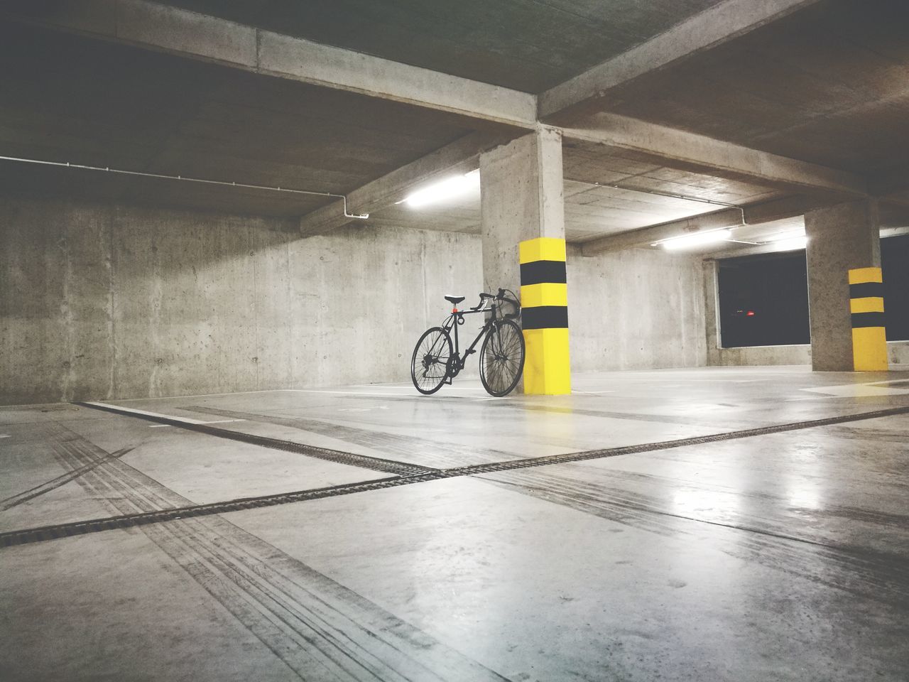 bicycle, transportation, indoors, illuminated, built structure, yellow, architecture, no people, parking garage, day