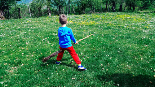 Rear view of boy playing on field