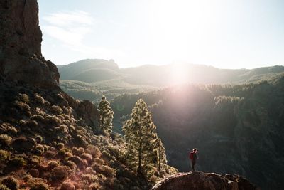 Woman standing on mountain against sky