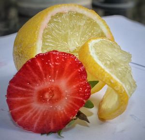 Close-up of lemon with strawberry on table