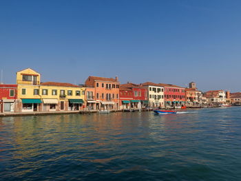 View of canal in city against clear sky