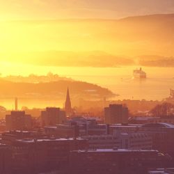 Silhouette of city against sky during sunset