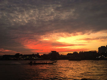 Scenic view of sea against dramatic sky during sunset