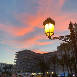 Low angle view of illuminated street light against building