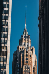 Low angle view of buildings against clear blue sky