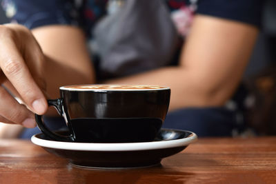 Midsection of coffee cup on table