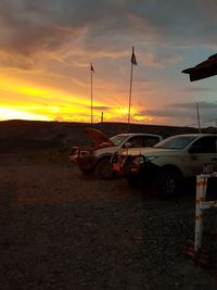 Cars on road against sky during sunset