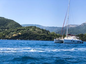 Sailboat sailing on sea against clear sky