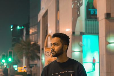 Young man in illuminated city at night