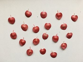 Close-up of red berries over white background