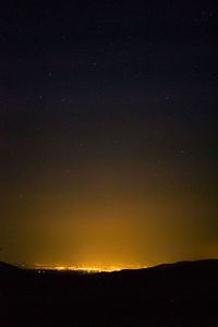 Silhouette landscape against sky at night