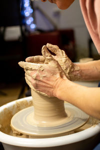 The girl's hands make a jug on a potter's wheel