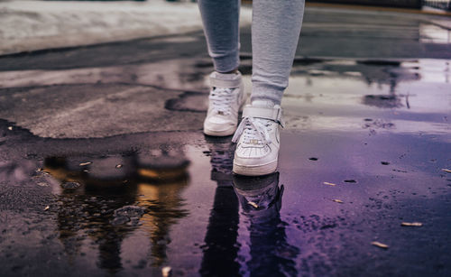 Low section of man standing on puddle