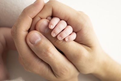 Cropped image of baby on bed