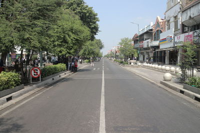 Empty road amidst buildings against sky