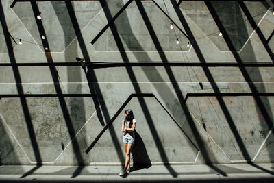 Full length portrait of woman standing on escalator