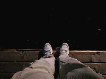 Low section of people relaxing on wood at night