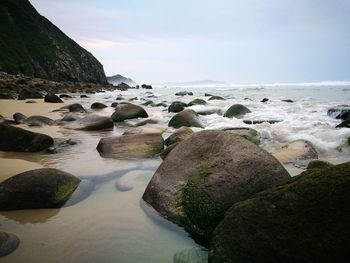 Rocks on beach against sky