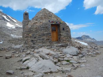 Built structure on rocky mountain against sky