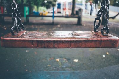 Close-up of wet swing at park during rainy season