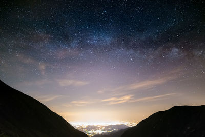 Scenic view of silhouette mountains against sky at night