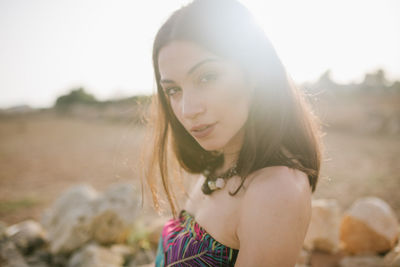 Portrait of beautiful young woman lying on land