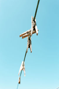 Low angle view of crane against clear blue sky