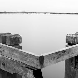 Close-up of wooden post by sea against clear sky