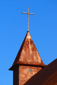 Low angle view of cross against clear blue sky