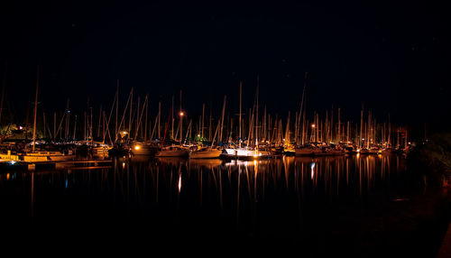 Reflection of boats in water at night