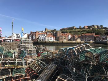 Scenic view of harbor against buildings against clear blue sky