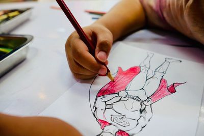 Close-up of hand holding paper painting