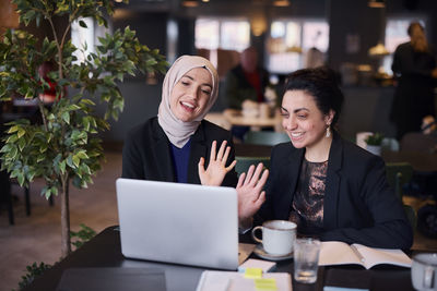 Businesswomen using laptop in cafe