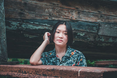 Portrait of beautiful young woman against wall
