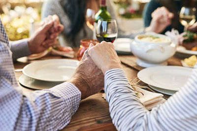 Cropped hand of man preparing food on table