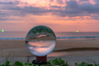 Close-up of water on beach against sky during sunset