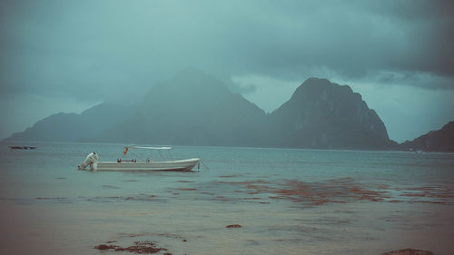 Scenic view of sea and mountains against sky