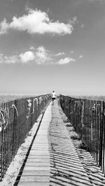 Pier on footbridge against sky
