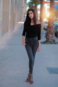 Full length portrait of young woman in city