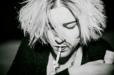 Close-up of young woman lighting cigarette