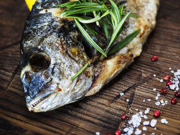 High angle view of grilled gilthead bream garnish with herbs served in plate