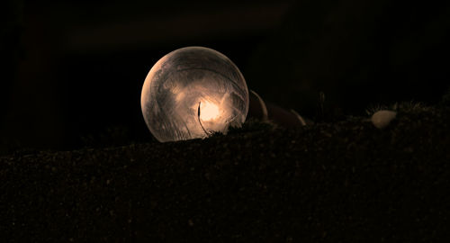 Low angle view of illuminated moon against black background